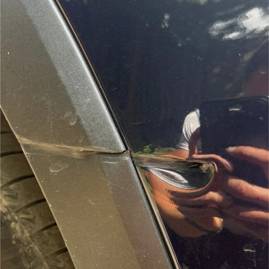 Dent and scuff on a front wing and wheel arch trim before repair